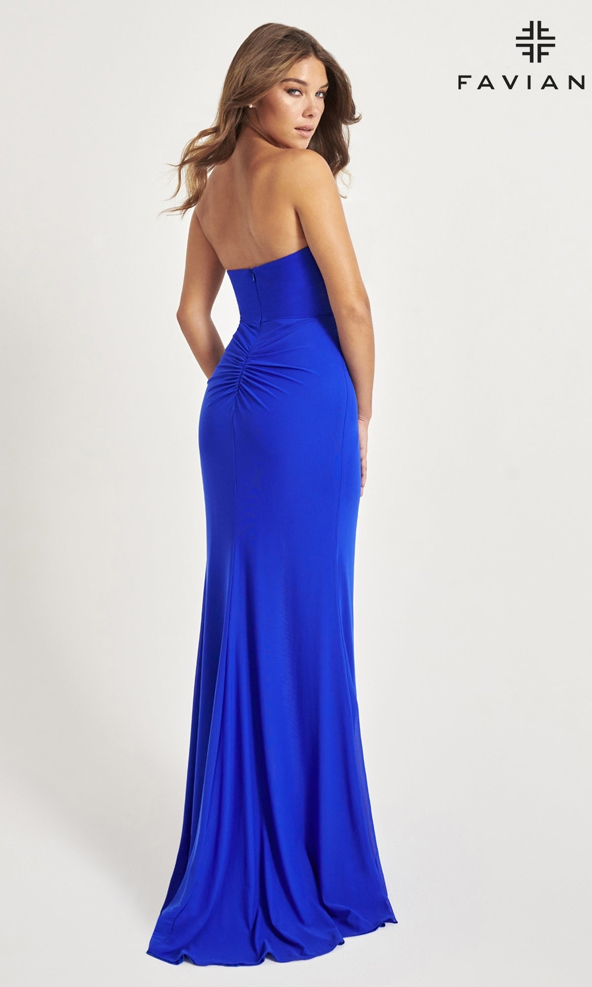 A woman models the Faviana Strapless Sweetheart Long Prom Dress 11046 in royal blue, standing with her back turned and looking over her shoulder. Faviana logo displayed in the top right corner.
